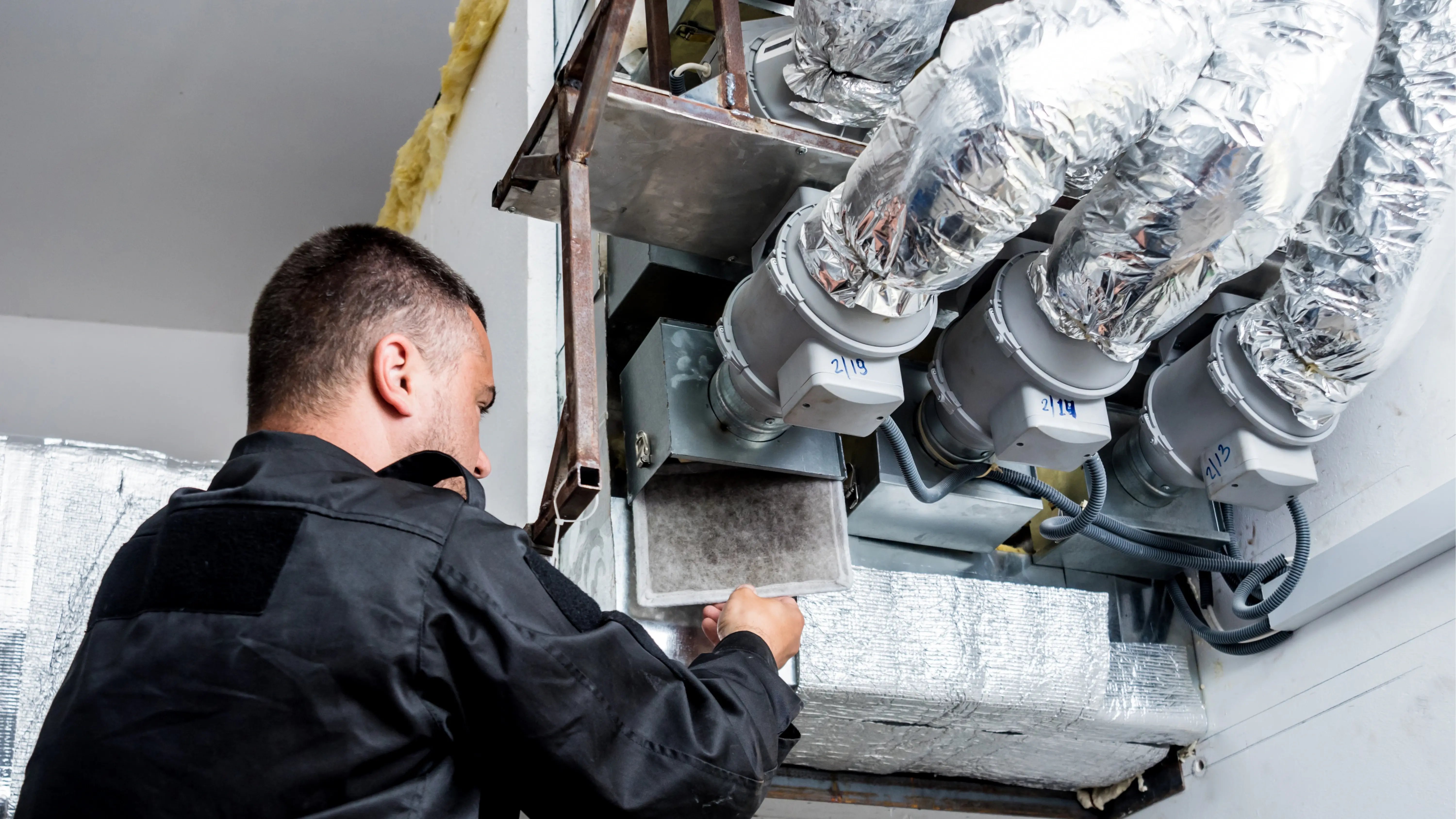 A photo of a man working on an AC system